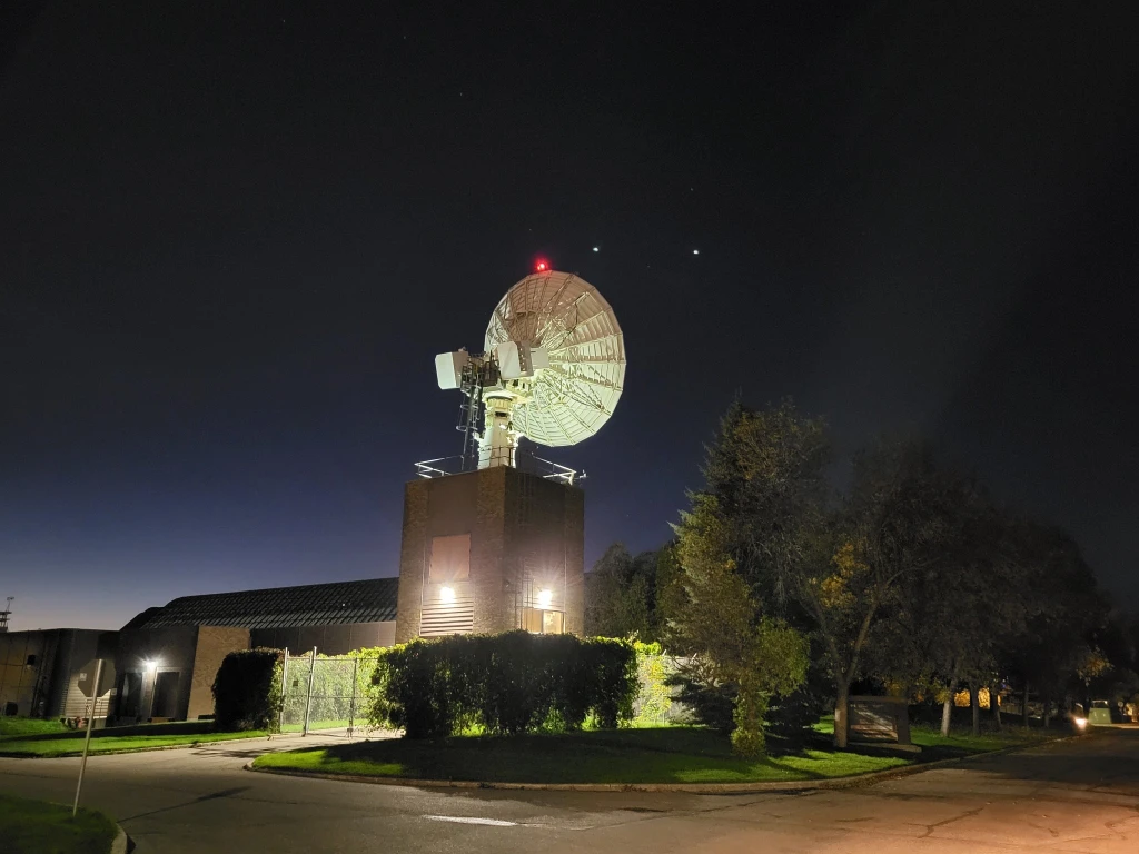 A satellite dish at the University of Saskatchewan, with a starry sky as the backdrop.